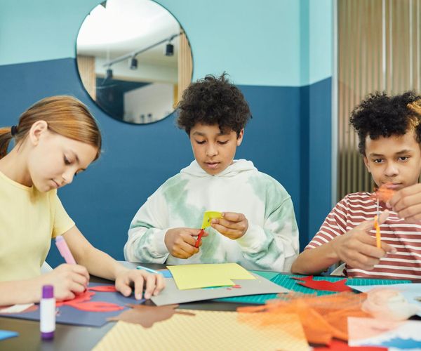 Group of diverse children learning yoga in a bright studio.